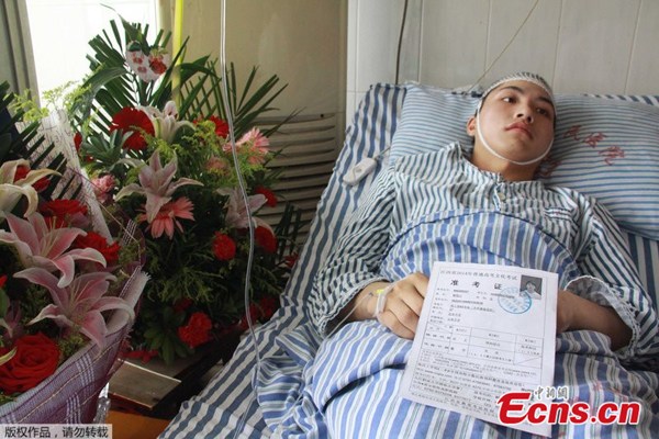 Liu Yanbing lies in bed after he was injured to save others from a knife attack on a bus that takes him to attend the national college entrance exam. [Photo/CFP]