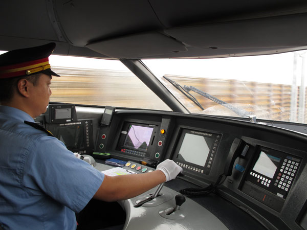 A driver at the controls of the Lanzhou-Xinjiang bullet train during a test run on the high-speed line earlier this month. GAO QIHUI / CHINA DAILY 