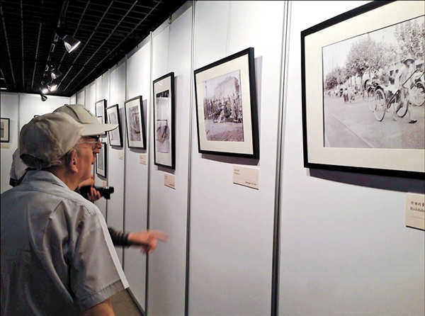 Two men study one of the photographs on display at the Shanghai Municipal Archives yesterday. 