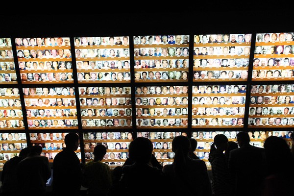 Visitors examine photos of survivors at the Nanjing Massacre Memorial Hall on April 5, Tomb Sweeping Day. At least 300,000 Chinese civilians and unarmed soldiers were killed by invading Japanese troops after they took the then Chinese capital in December 1937 and began a rampage of arson, looting, raping and killing that lasted more than six weeks. LI WENBAO / FOR CHINA DAILY