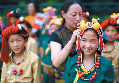 A teacher helps a Tibetan student with her headdress as they wait outside the Great Hall of the People in Beijing before a welcoming ceremony for Republic of Congo President Denis Sassou Nguesso on Thursday. Feng Yongbin / China Daily