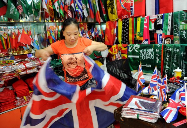 A vendor packs the Union Jack that will be shipped for sale in the United Kingdom in Yiwu, Zhejiang province. The UK has become an important trade partner of China with fast-growing bilateral ties. [Photo by Zhang Jiancheng/For China Daily]