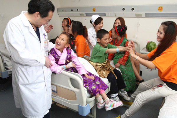 Staff and volunteers hold a birthday party for five children at Shanghai Yuanda Hospital. Wang Rongjiang / for China Daily