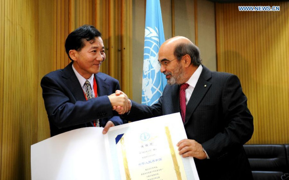 The UN Food and Agricultural Organization(FAO) Secretary General Jose Graziano da Silva(R) awards a diploma to Chinese Deputy Agriculture Minister Chen Xiaohua during the awarding ceremony at FAO headquarters in Rome, Italy, on June 16,2014.[Xinhua/Xu Nizhi]