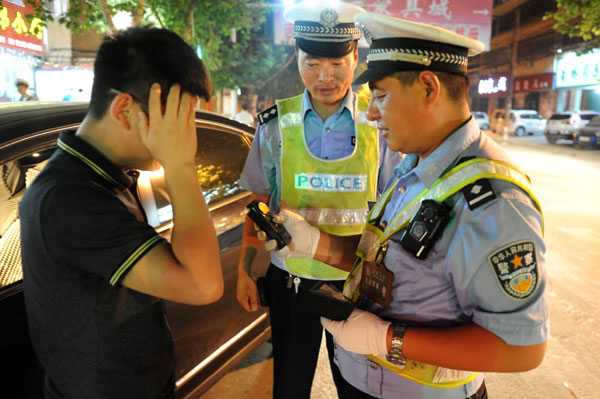 Traffic police officers test the blood-alcohol level of a driver in Shangqiu, Henan province, on Friday. Bai Xianglin / For China Daily