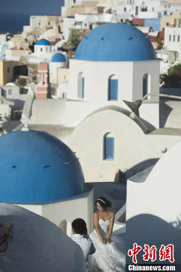 Tourists take wedding photos on the Santorini islands in Greece. [File photo]
