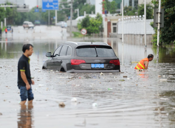 A car is stranded on a fl ooded street in Changsha, Hunan province, on Friday. Heavy rainstorms have inundated streets, paralyzing traffi c in parts of the city. YANG HUAFENG / FOR CHINA DAILY 