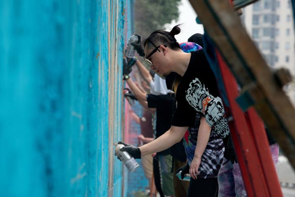 Artists of graffiti group ABS Crew cooperate to paint a wall in Beijing. Wei Xiaohao / China Daily