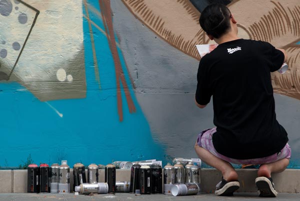 A graffiti artist works on an unfinished project on the wall of a back alley in Beijing.Wei Xiaohao / China Daily