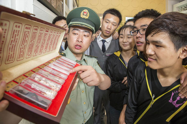 A police officer shows samples of different narcotics to employees working at entertainment venues in Wenzhou, Zhejiang province, on Tuesday. CAI KUANYUAN / FOR CHINA DAILY