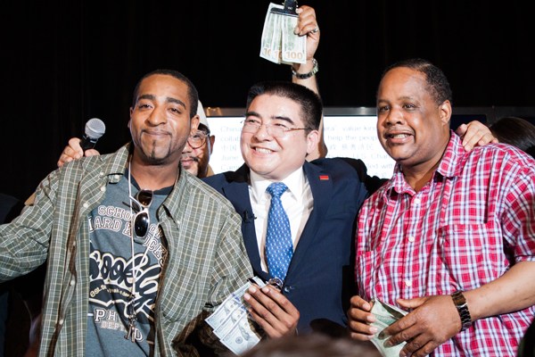 Chen Guangbiao (center) gives money to two representatives of the underprivileged New Yorkers from the 300 invitees during the luncheon at the Loeb Boathouse in Central Park in New York on Wednesday. Li Ang for China Daily