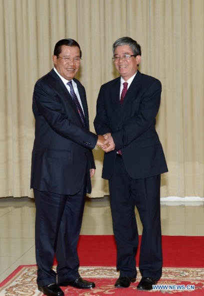 Cambodian Prime Minister Hun Sen (L) shakes hands with Pham Quang Vinh , Vietnamese premier's special envoy and Vietnamese deputy foreign minister, at the Peace Palace in Phnom Penh, Cambodia, June 25, 2014. (Xinhua/Sovannara)