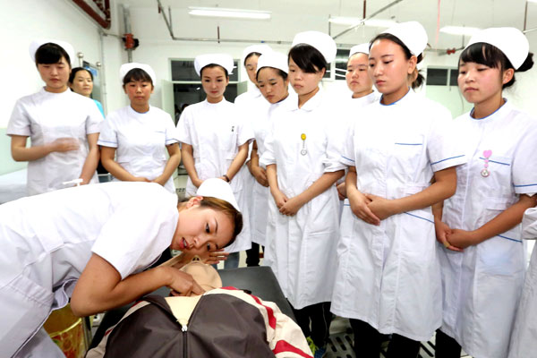 Nursing students in Hami prefecture, Xinjiang Uygur autonomous region, learn first-aid during a class on Thursday at the prefecture's first senior vocational school. CAI ZENGLE / XINHUA
