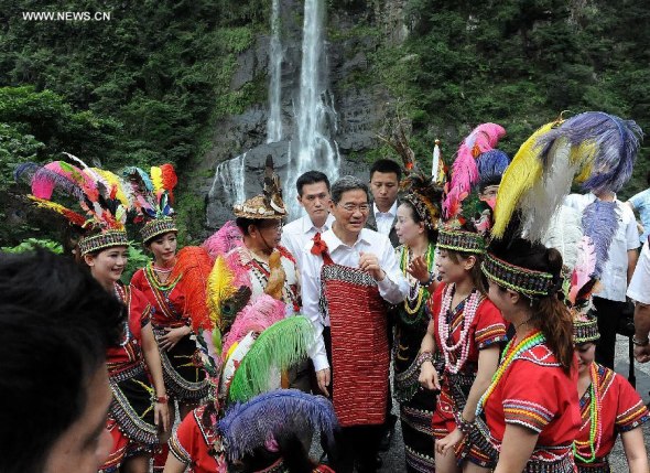 Zhang Zhijun, director of the Taiwan Affairs Office of China's State Council, talks with people from the Atayal tribe, a tribe of Taiwanese aborigines, in Wulai mountain areas of New Taipei City, southeast China's Taiwan, June 26, 2014. Zhang visited the mountain areas on Thursday.(Xinhua/He Junchang)