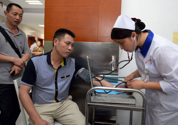 Blood pressure is taken at a special World Cup clinic at Chengdu No 3 People's Hospital in Sichuan province. The clinic is open 24 hours a day to treat fans who fall ill while watching games at night. [Li Xiangyu/For China Daily]