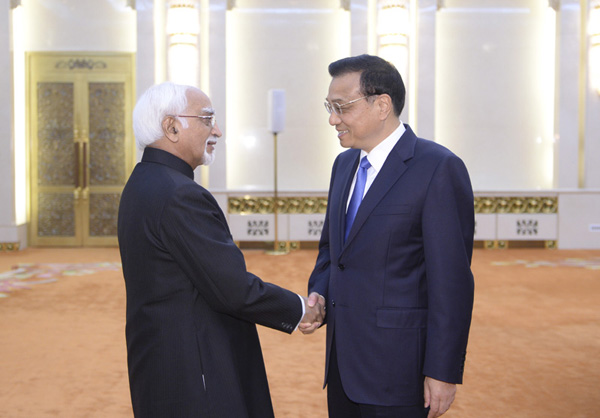 Premier Li Keqiang shakes hands with Indian Vice-President Mohammad Hamid Ansari during meetings in Beijing, June 28, 2014. [Photo/Xinhua]