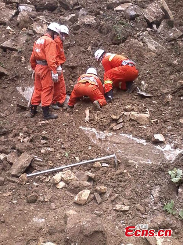 Firefighters try to rescue the missing people after a landslide in southwest China's Yunnan Province on Monday, June 30, 2014. [Photo: China News Service/Zhong Xin]