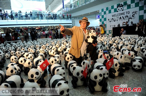 The designer of paper panda Paulo Grangeon poses with his pandas at Hong Kong International Airport in Hong Kong, south China, June 9, 2014. [Photo: China News Service / Tan Daming]