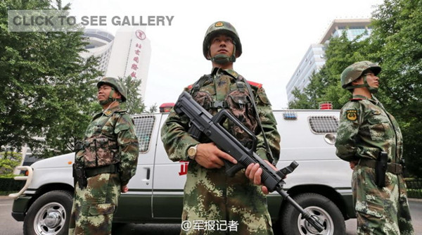 Armed police officers carrying guns go on patrol in a street in Beijing on June 10, 2014. The cruiser shown on the photo is equipped with high explosive squash heads, explosion-proof blankets, vehicle stations, and vehicle GPS systems. [Photo: Weibo account of PLA Daily]