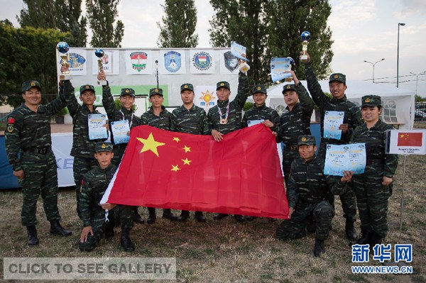 Chinese competitors pose for photos with trophies and the national flag at the 13th Police and Military Sniper World Cup in Budapest, Hungary, on June 17, 2014.