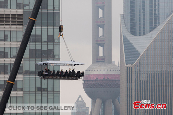  Dinner guests dine on a platform, 50 meters in the sky above Shanghai for a novelty experience costing 1,888 yuan ($303) to 8,888 yuan ($1,429) on June 27, 2014. [Photo: China News Service / Zhang Hengwei]