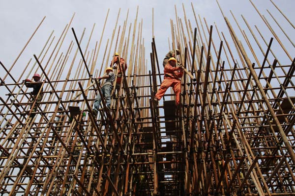 Workers set up scaffolding at a construction site in Jiujiang, Jiangxi province. China should be disciplined about GDP growth as it transforms its pattern of economic growth, experts say. ZHANG HAIYAN/CHINA DAILY
