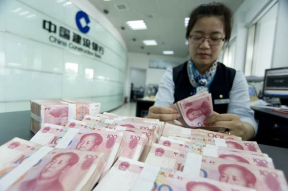 An employee counts banknotes at a China Construction Bank Corp branch in Haian, Jiangsu province. The banking regulator has adjusted the loan-to-deposit ratio for commercial lenders in a move to shore up the economy.XU JUNBAI/CHINA DAILY