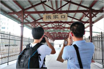 Passengers take photos at the Zhangjiakou Railway Station in northern China's Hebei Province on June 28, 2014. Zhangjiakou Railway Station, with a history of 105 years, will stop operation starting July 1, 2014. [Photo: Beijing News]  