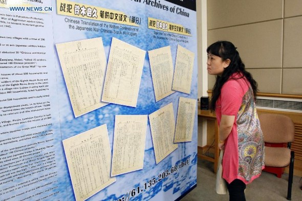 A reporter views a poster board before a press conference in Beijing, capital of China, July 3, 2014.  (Xinhua/Shen Bohan)