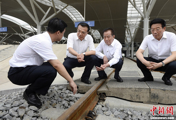 Premier Li Keqiang chats with local officials at a construction site for a new high-speed railway line in Changsha, the capital of Hunan province on Thursday, July 3, 2014. [Photo/Liu Zhen]