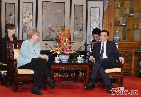 Chinese Premier Li Keqiang (R) talks to German Chancellor Angela Merkel during a meeting at the Diaoyutai State Guesthouse in Beijing, July 6, 2014. [Photo: China News Service/Liu Zhen] 