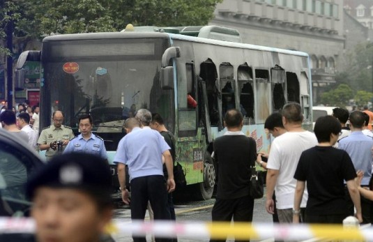 Police cordon off the site where a bus was in flames in Hangzhou, capital of east China's Zhejiang Province, July 5, 2014. Thirty-two injured people were sent to hospitals after a bus caught fire on Saturday afternoon in downtown Hangzhou.  (Xinhua/Han Chuanhao)
