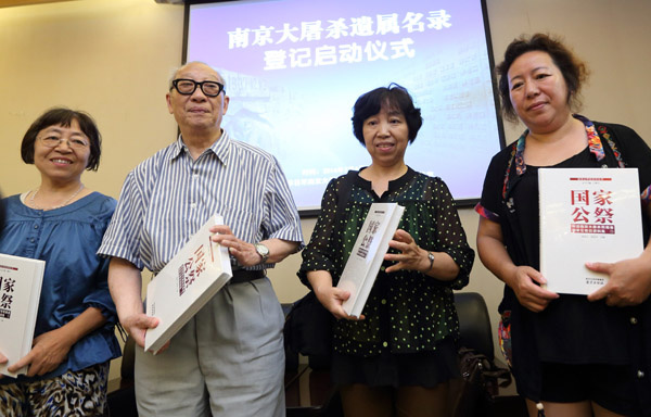 Yu Changxiang (second from left), a Nanjing Massacre survivor, and his family members receive books titled Guo Jia Gong Ji (National Public Memorial) as mementos at a ceremony to mark survivors registration on the massacre in Nanjing, on Sunday. [Photo by Yang Bo/China News Service]