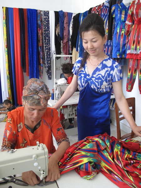 Sharwangul (right) teaches a worker how to make a traditional ethnic Uygur dress in her own studio at a garment factory in Huocheng, Xinjiang Uygur autonomous region.[Yang Wanli/China Daily]