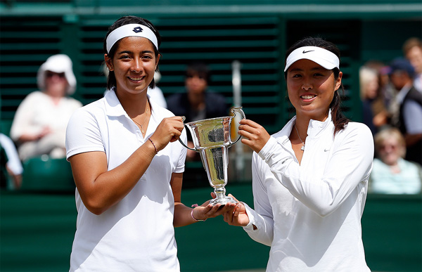 Tami Grende of Indonesia, left, and Ye Qiuyu of China hold the trophy after defeating Marie Bouzkova of the Czech Republic and Dalma Galfi of Hungary during their junior girls doubles final at the Wimbledon Tennis Championships in London, July 6, 2014. [Photo courtesy of All-England Lawn Tennis Club]