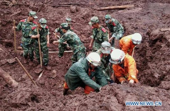 Photo taken with a cell phone shows rescuers searching for victims of a mudslide in Ludian county of Zhaotong city, southwest China's Yunnan province, July 7, 2014. (Xinhua/Zhang Rui)