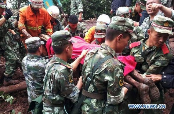 Photo taken with a cell phone shows rescuers carrying a victim of a mudslide in Ludian county of Zhaotong city, southwest China's Yunnan province, July 7, 2014.  (Xinhua/Zhang Rui)