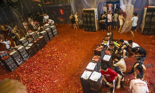 Hundreds of people became soaked in juice from 10 tons of tomatoes during Splash Wars at Mako Livehouse in Shuangjing, Chaoyang district, on July 6. For 100 yuan ($16), people were invited to pelt each other with tomatoes purchased from a local wholesale market. Despite some concerns about food waste, event organizers assured the public only tomatoes unsuitable for human consumption were used. The overall response from participants was positive, but some complained about the lack of shower facilities and firmness of tomatoes. Photos: Li Hao/GT