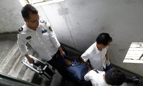 An ambulance crew carry a patient downstairs. Photo: Yang Hui/GT