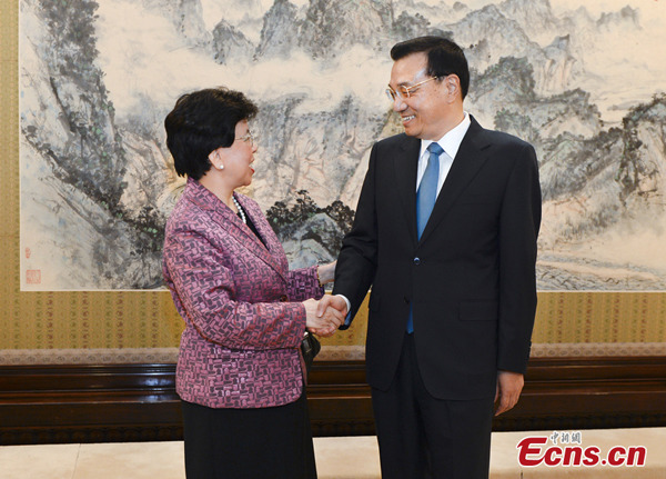 Chinese Premier Li Keqiang (R) shakes hands with Margaret Chan, director-general of the World Health Organization (WHO), in Beijing, capital of China, July 8, 2014. [Photo: China News Service/Liu Zhen]