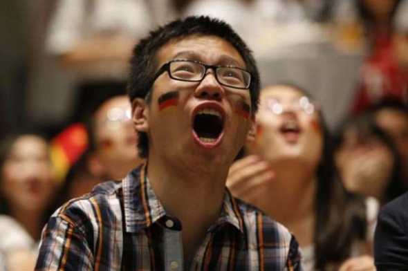 A Chinese football fan supporting German football team is nervously watching Germany v Portugal match in Group G of the 2014 FIFA World Cup on June 17, 2014. [Photo: Xinhua]
