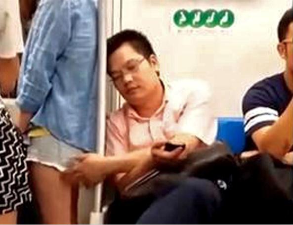 This video grab shows Wang Qikang touching the thigh of a young woman on a subway train in Shanghai on June 29.