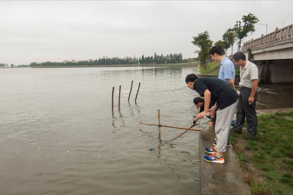 Environmental experts and volunteers collect water samples during the one-day field trip around Shanghai.