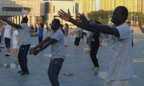 Three men from South Sudan learn group square dancing while working in Panjin, Liaoning province. Photo: lnd.com.cn