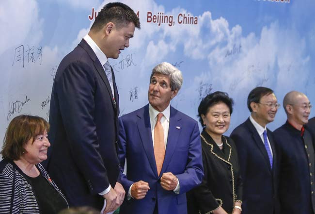 US Secretary of State John Kerry looks up at former NBA player Yao Ming in company with Chinese Vice-Premier Liu Yandong (at Kerrys left) and other dignitaries attending a discussion on Wednesday about combating wildlife trafficking. ZHANG HAO / CHINA NEWS SERVICE