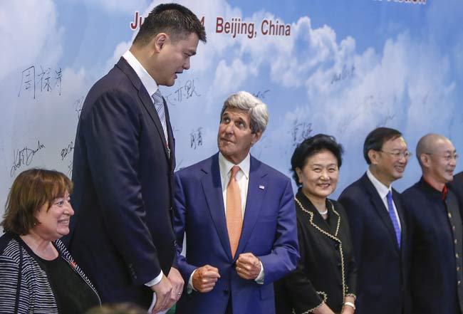 US Secretary of State John Kerry looks up at former NBA player Yao Ming in company with Chinese Vice-Premier Liu Yandong (at Kerry’s left) and other dignitaries attending a discussion on Wednesday about combating wildlife trafficking. ZHANG HAO / CHINA NEWS SERVICE