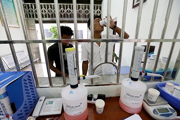 Drug users from Myanmar regularly collect doses of methadone from the Better Clinic in Ruili, Yunnan province.[Photo by Jiang Dong / China Daily]