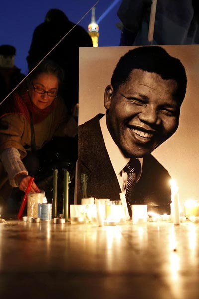 People place candles near a photo as they pay tribute to former South African President Nelson Mandela at the Trocadero square, in front of the Eiffel Tower in Paris December 15, 2013. [Photo/Agencies]