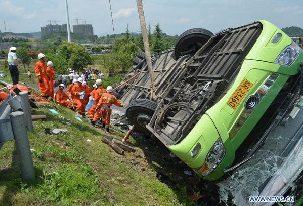 Rescuers work on the scene of a passenger coach rollover accident along the Hangzhou-Huizhou highway in Hangzhou, capital of east China's Zhejiang Province, July 12, 2014. (Photo/Xinhua)
