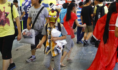 A boy in a mask moves through the exhibition area. Photo: Yang Hui/GT